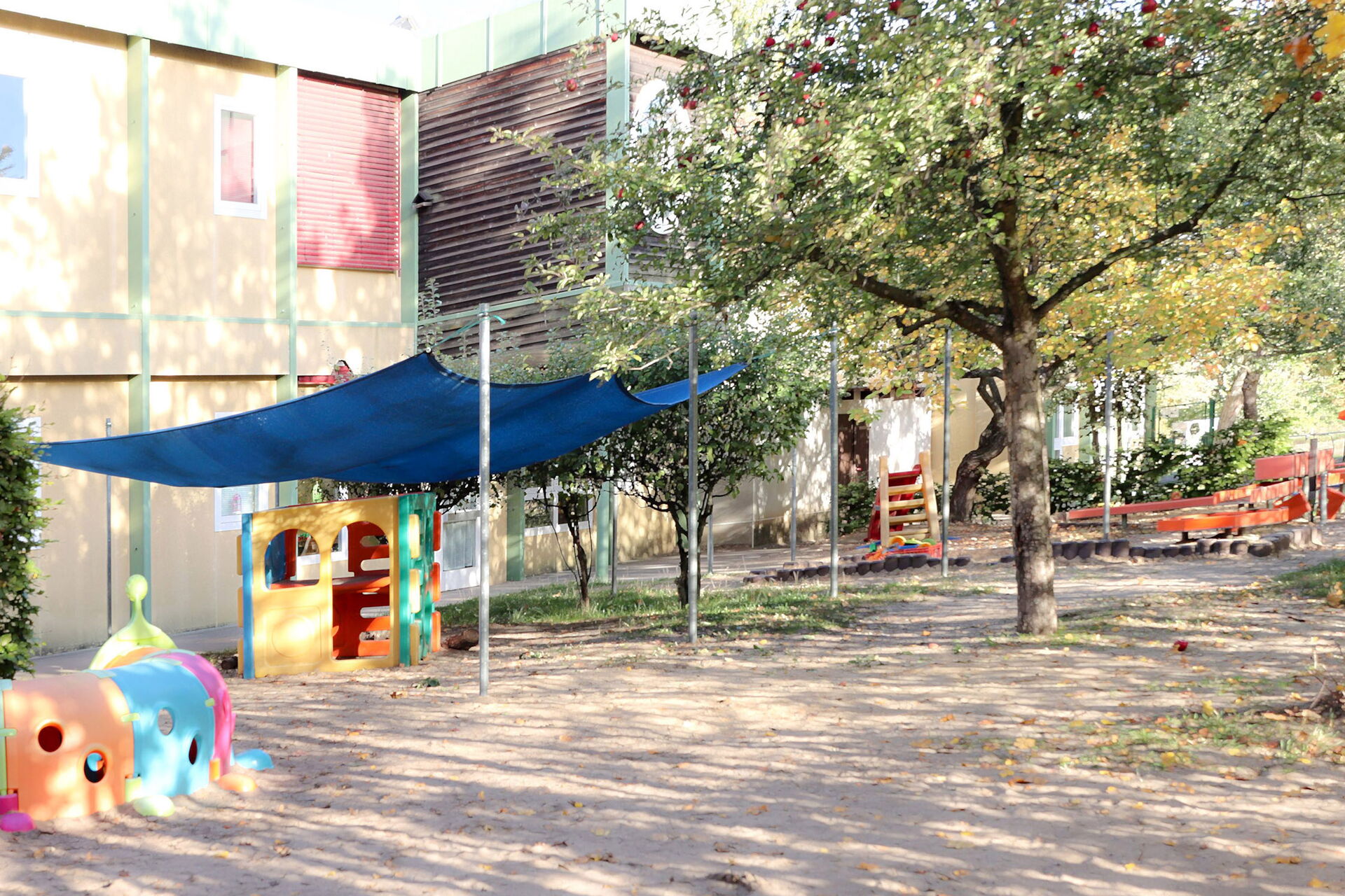 Spielplatz vor einem Kita Gebäude.