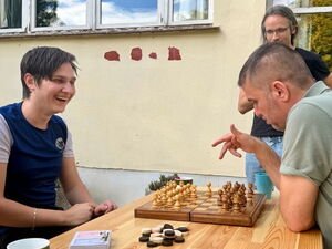 2 Menschen spielen gut gelaunt Schach.
