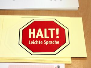 Schild: Halt! Leichte Sprache: Teilnehmer*innen können das Schild hochhalten, wenn sie etwas nicht verstehen und eine Übersetzung in Leichter Sprache benötigen