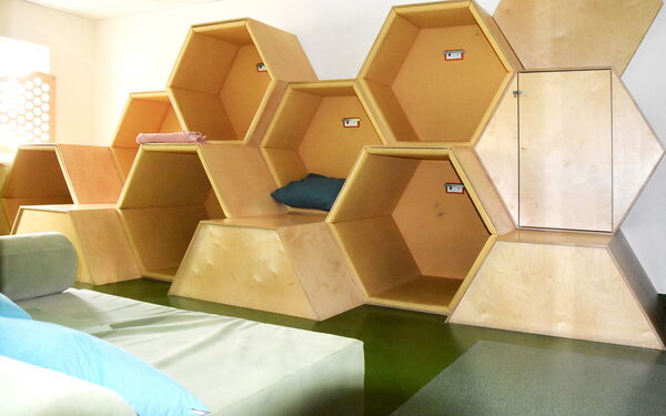 Wabenraum. Ein großes Bienen-Waben-Gebilde aus Holz mit Decken und Kissen zum reinsetzen und lümmeln.