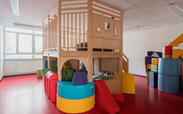 Im Spielzimmer. Ein großes Holz Gerüst von Boden bis Decke zum Spielen und Lümmeln. Haus mit Dachgarten bietet Spielspaß auf zwei Ebenen.