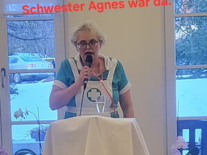 Büttenrede von Schwester Agnes. Frau verkleidet als Krankenschwester mit Mikro in der Hand.