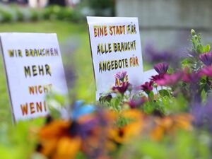 Blumenrabatte. Hinter die Blumen wurden zwei der Protestplakate gesteckt.