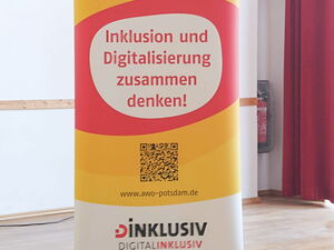 Roll up Banner vom Projekt DInklusiv. Gelb-rot-weißes Banner. In den weißen Blasen Text: Inklusion und Digitalisierung zusammen denken!