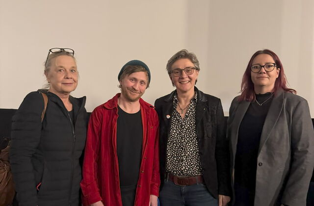 Gruppenbild vor der Leinwand. 3 Frauen und ein Mann stehen nebeneinander.
