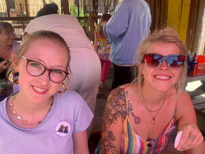 2 sommerlich gekleidete blonde Frauen lächeln in die Kamera.