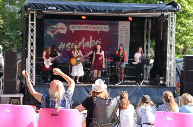 Mädchen Band auf der Bühne, begeistertes Publikum davor.