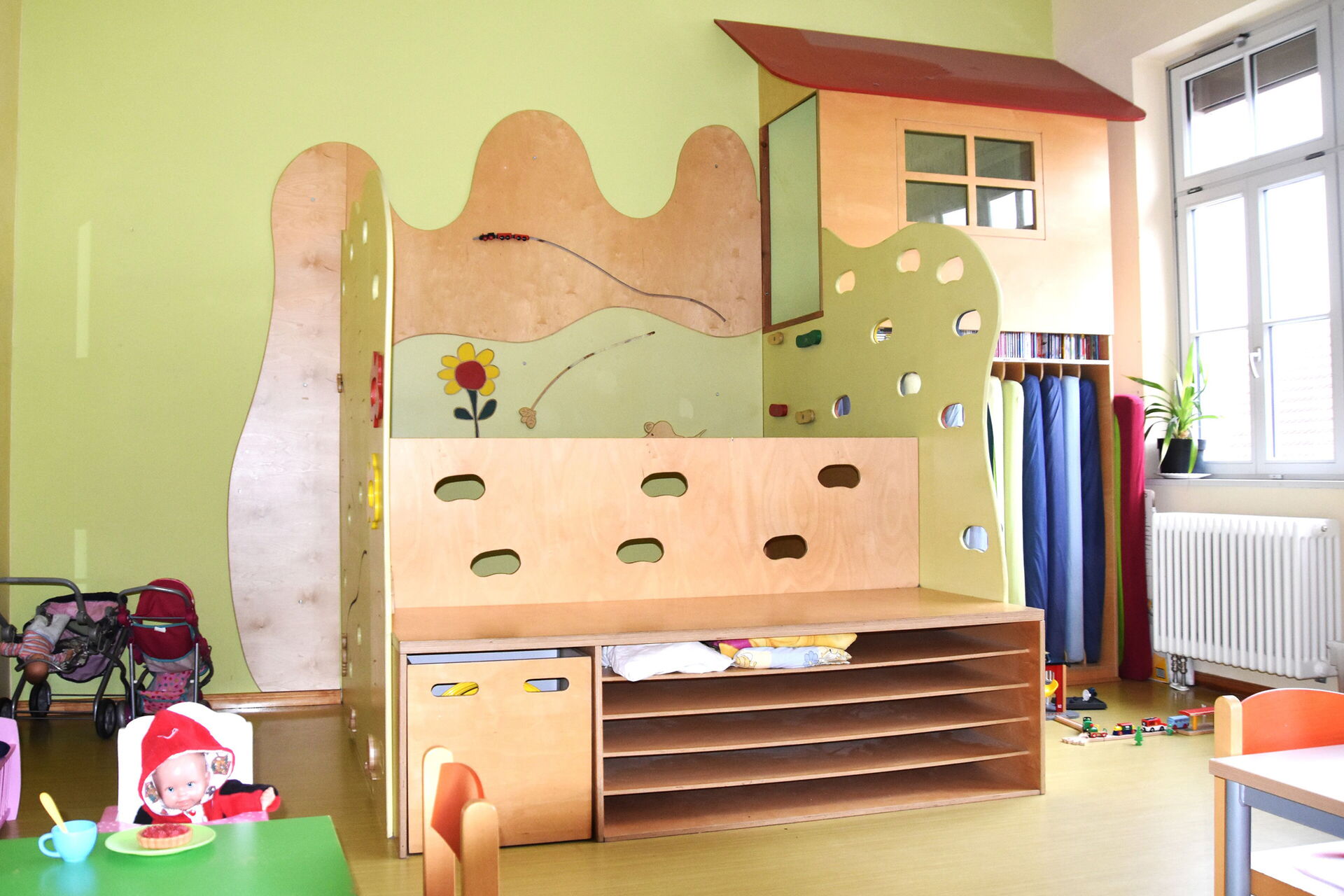 Eine Art Hochbett. Mehrere Ebenen zum klettern und ausruhen. Die Matratzen dafür sind in einem offenen Schrank aufgehangen.