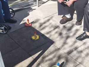 Senioren spielen ein Wurfspiel. Sie sitzen dazu draußen in der Sonne.