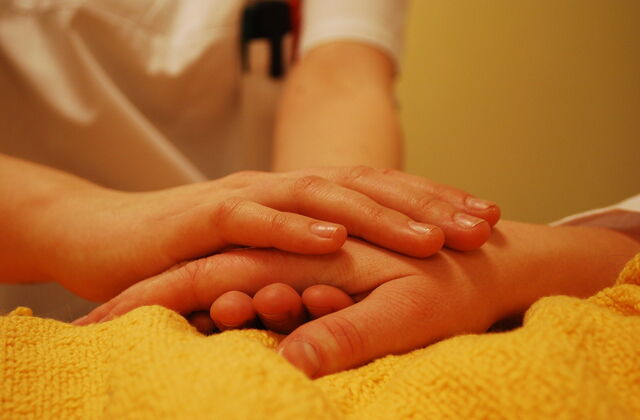 Das Bild zeigt eine Hand, die eine andere Hand hält