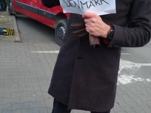Man mit Schild in der Hand mit der Aufschrift: Free ride to Denmark