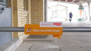 Auf einem Schild steht der Hashtag Eine Barriere weniger