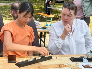 2 Frauen am Tisch spielen Scrabbel, bei sehen konzentriert auf ihre Spielsteine.
