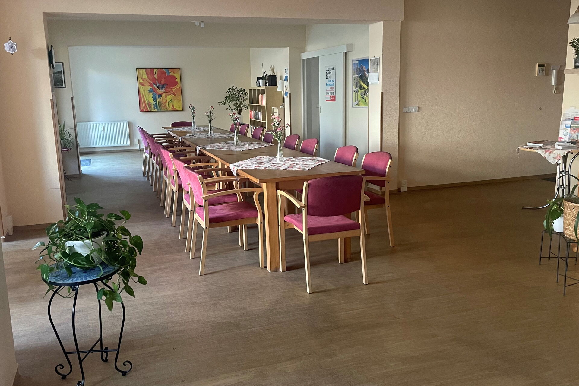 in der Mitte des großen Begegnungsraumes steht eine lange Tafel mit Stühlen daran.