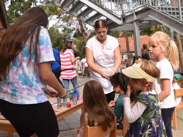 Hier sehen sie Kinder und Erwachsene beim Haare flechten