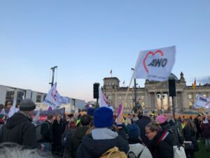 Viele Menschen vor dem Reichstag in Berlin, einige schwenken Fahnen unteranderem AWO Fahnen.