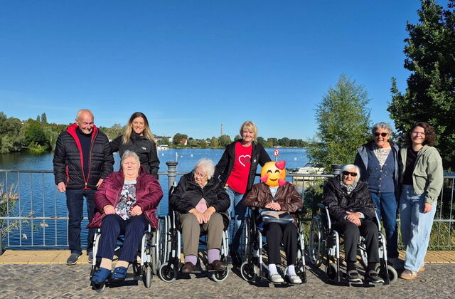 Gruppenfoto: 9 Menschen, darunter vier Seniorinnen im Rollstuhl. Dahinter Senioren und Betreuerinnen stehen dahinter.