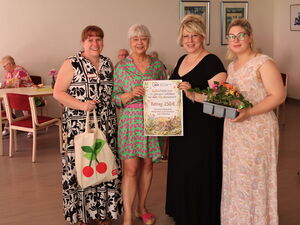 Gruppenbild: 4 Frauen in festlichen und sommerlichen Kleidern. In der Mitte wird der Gutschein über 250 Euro inn die Kamera gehalten.
