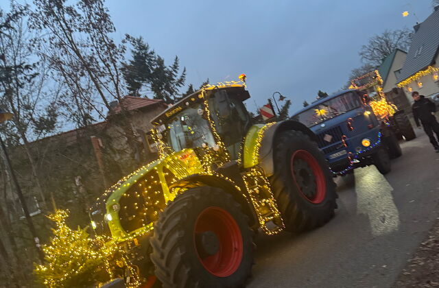 Traktor mit Lichterketten geschmückt, dahinter ein weiteres Fahrzeug mit Lichtern