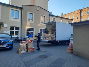 Drei Männer stapeln Spendenkartons in einen LKW