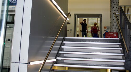Eine Treppe zu beiden Seiten mit Geländer in einem Gebäude.