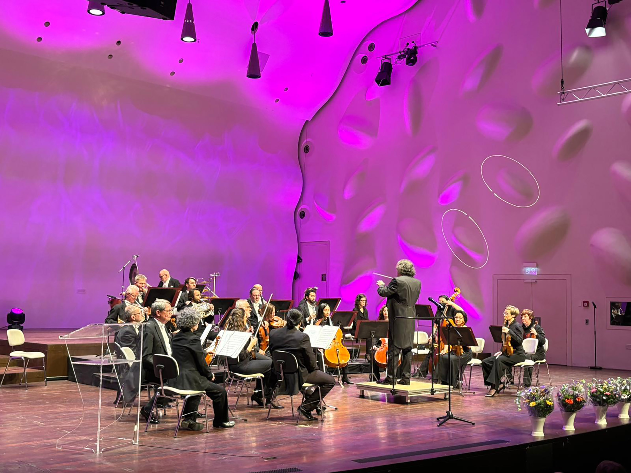 Orchester mit Dirigent auf der Bühne.
