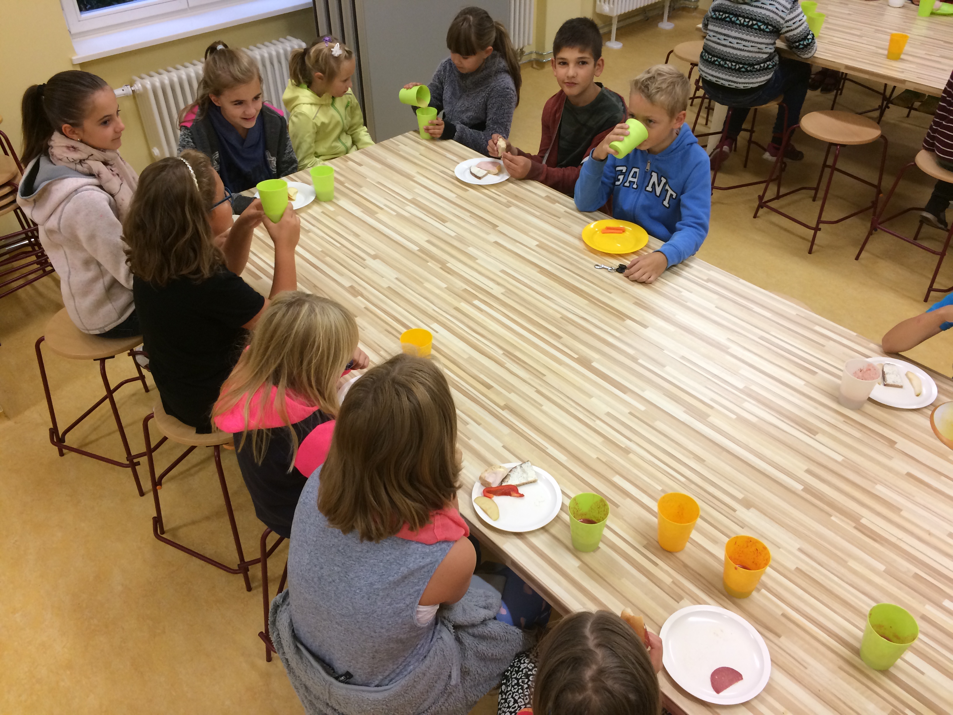 9 Kinder am Frühstückstisch beim Essen.