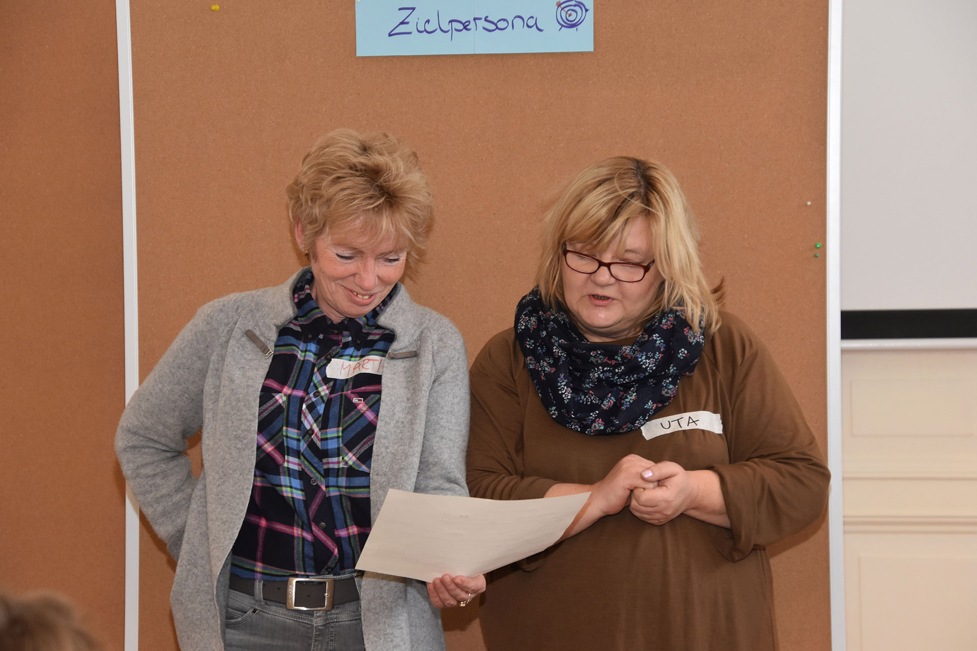 Zwei Frauen schauen auf ein Blatt Papier