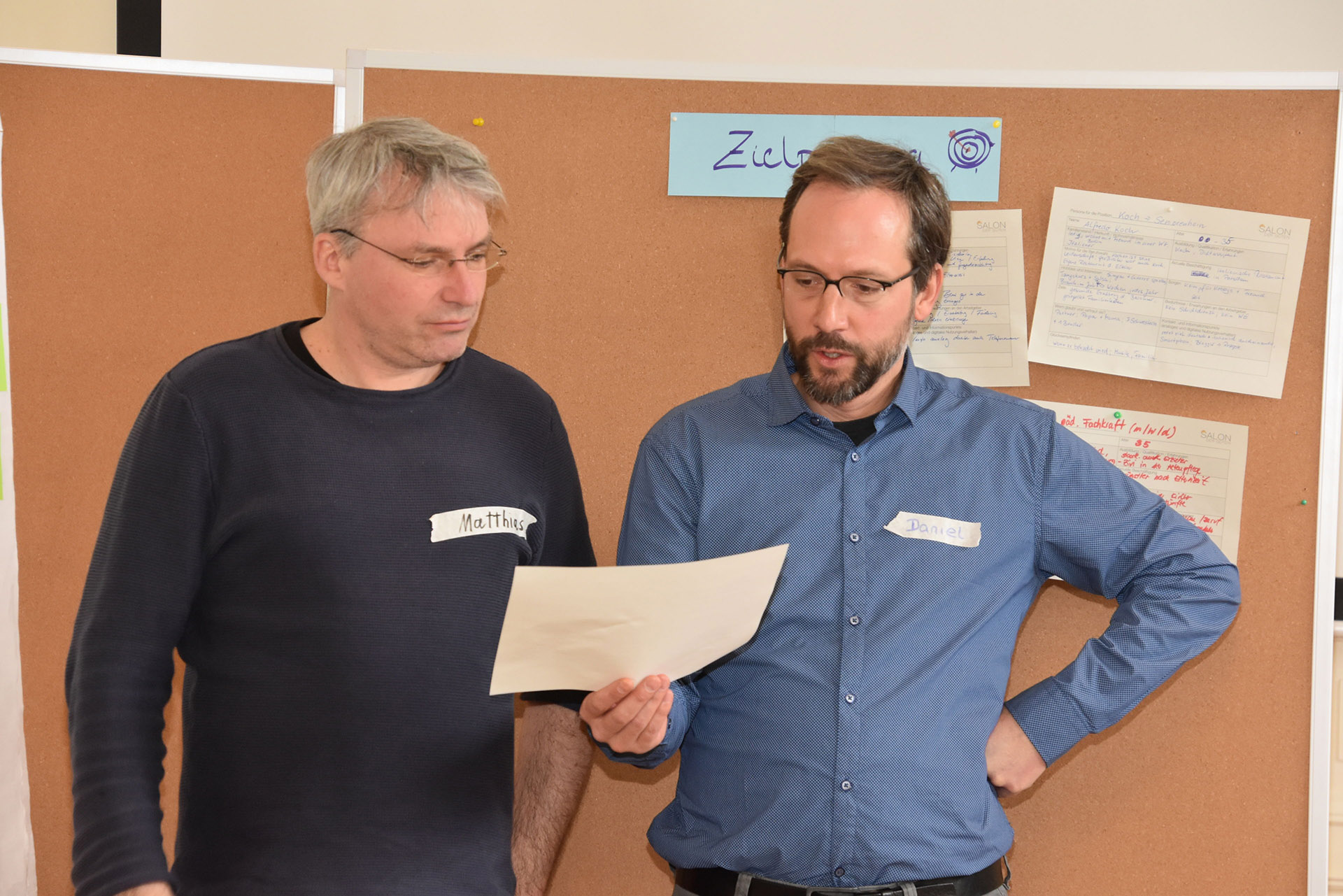 Zwei Männer schauen auf ein Blatt Papier