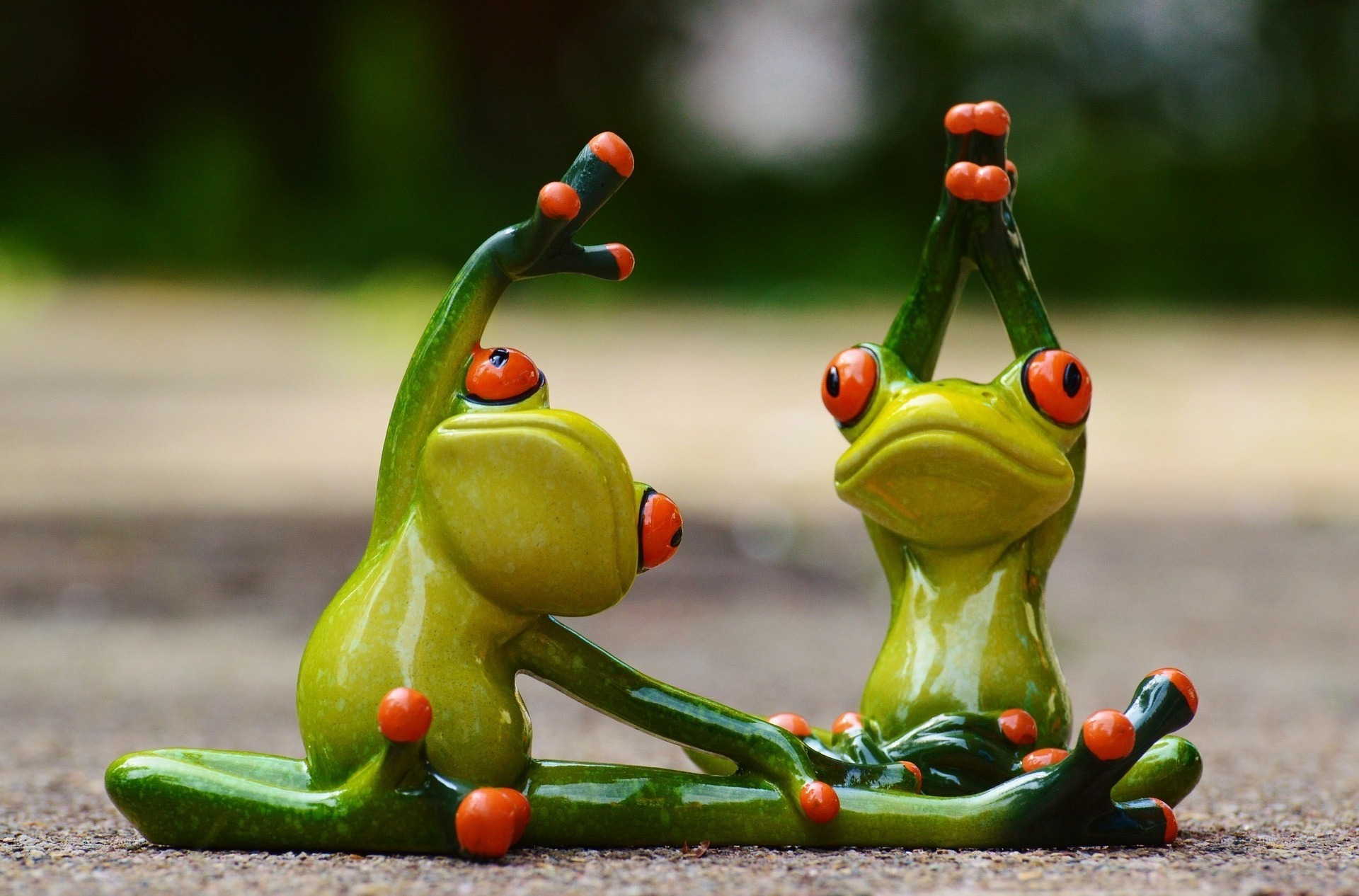 Zwei Froschfiguren die Gymnastik machen aus Keramik.