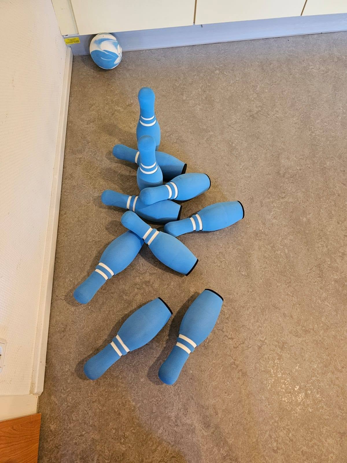 2 blaue Kegel stehen noch, die anderen hat der Ball, der in der Ecke liegt umgeworfen.