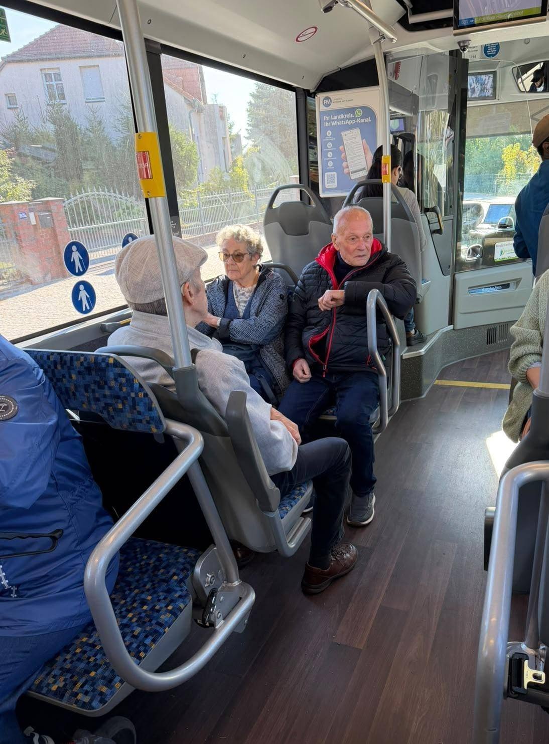 drei Senioren sitzen im Linienbus.