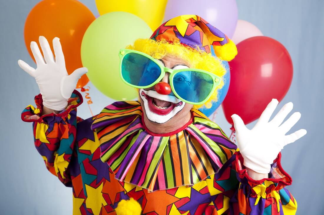 Lustiger Clown mit Hände unterhalb des Kopfes