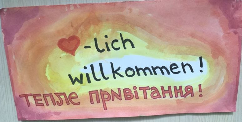 Das Foto zeigt ein handgemaltes Plakat, auf dem in Deutsch und Ukrainisch Herzlich Willkommen steht
