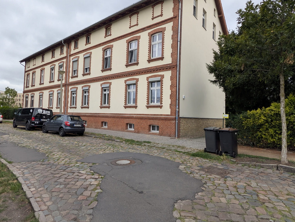 Schönes altes restauriertes Haus. Straße davor alt, Kopfsteinpflaster und vereinzelt Asphalt.